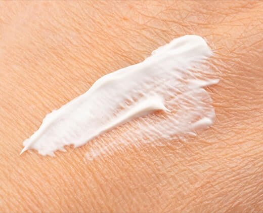 Zbliżenie na suchą skórę i zaaplikowany balsam nawilżający