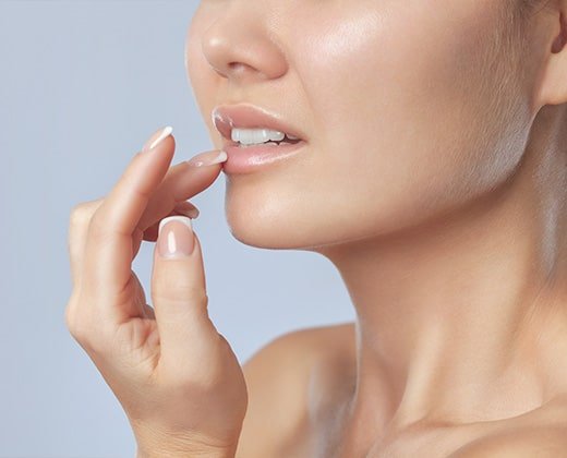 Uśmiechnięta kobieta po nałożeniu balsamu na suche usta